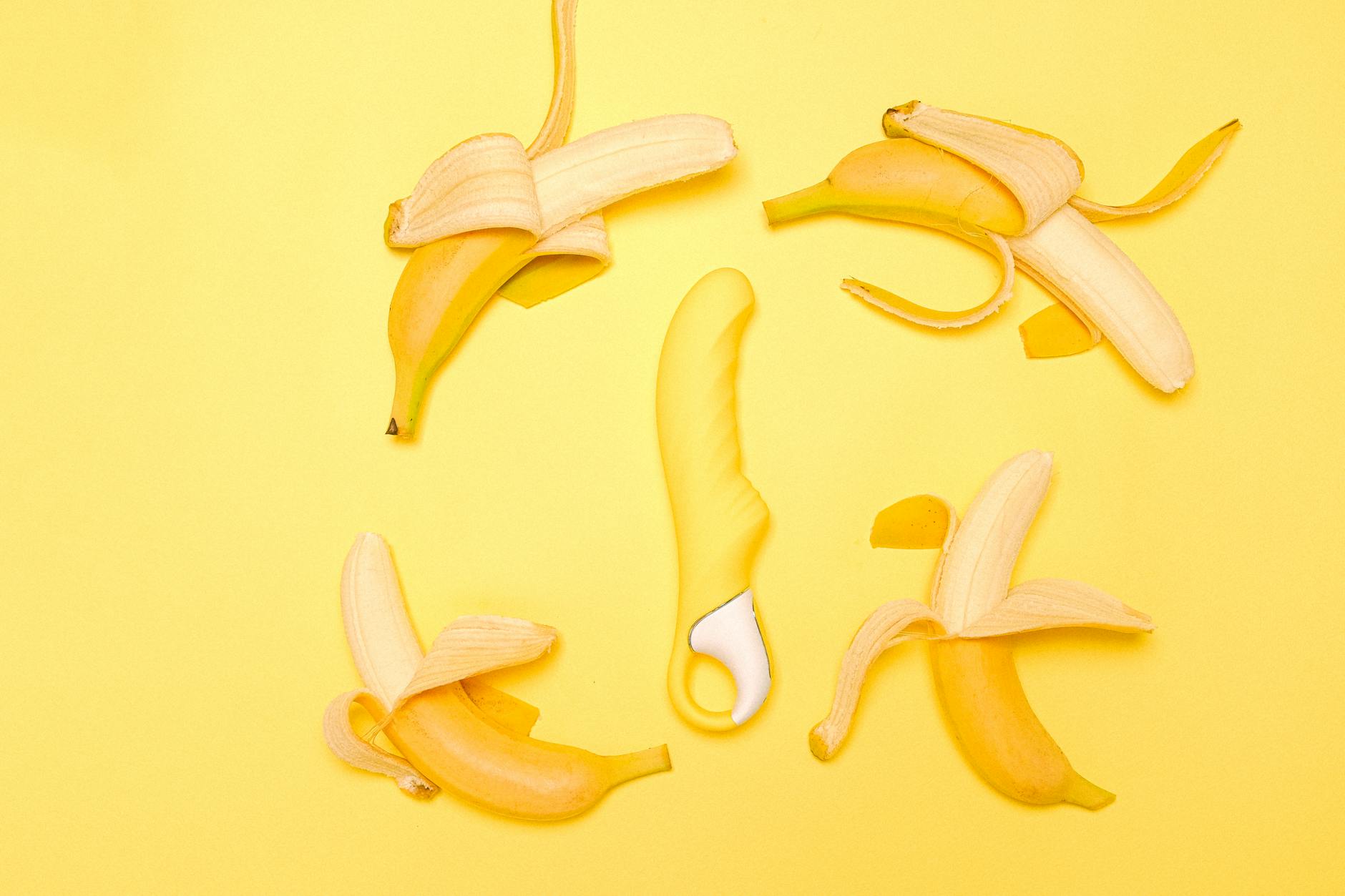Hand holding fresh lemon against vivid yellow background, symbolizing the fresh approach to pleasure with tissue-friendly methods