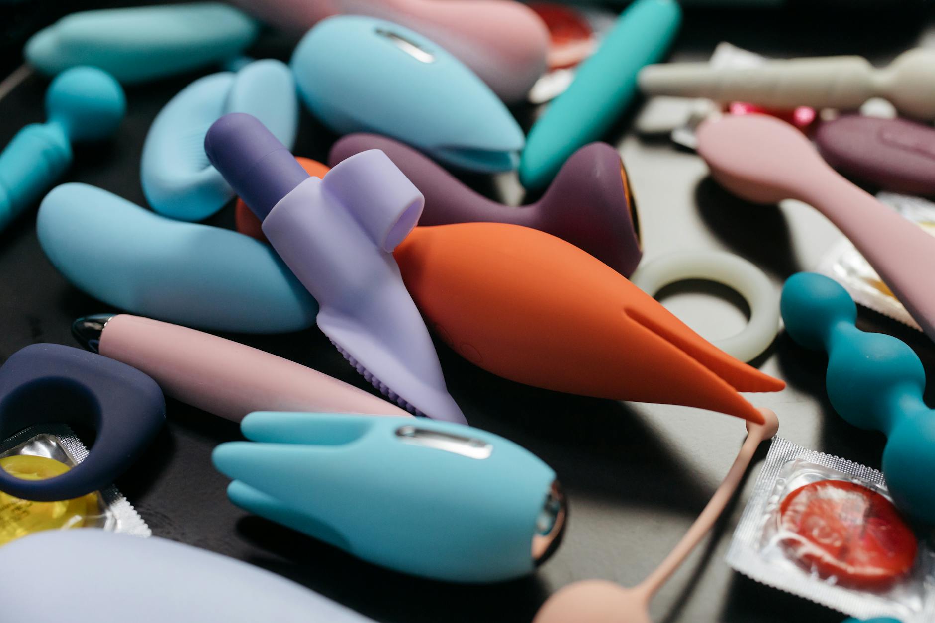 Close-up of hands holding a sleek lemon clitoral vibrator against a purple background