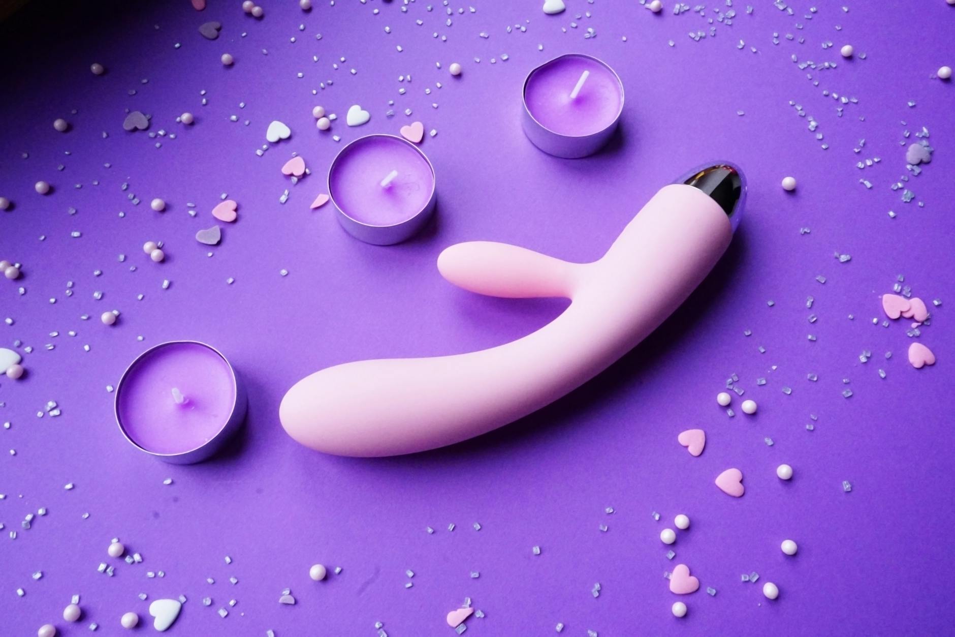 Colorful clitoral vibrators arranged on a bright yellow surface, representing pleasure and self-discovery.